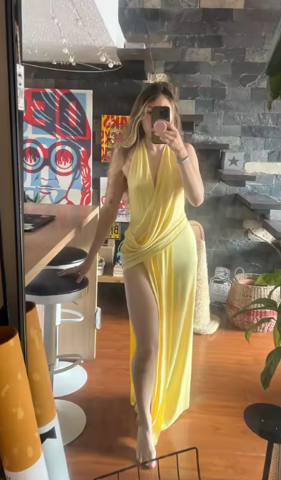 Clienta con el vestido largo amarillo halter con abertura en la pierna