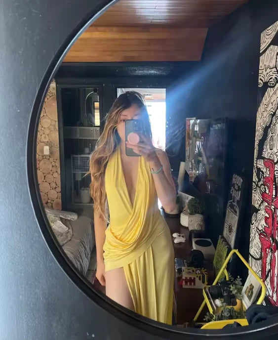 Clienta con el vestido largo amarillo halter con abertura en la pierna