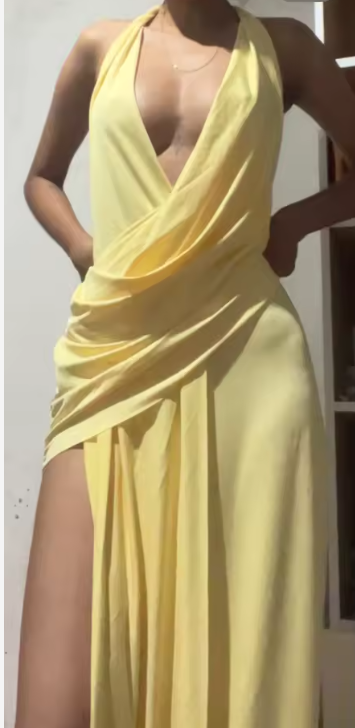 Clienta con el vestido largo amarillo halter con abertura en la pierna